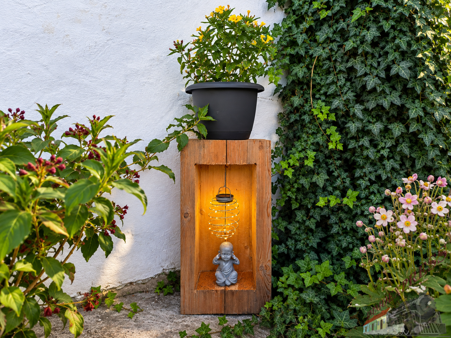 Beleuchtete Gartennische mit Blumen