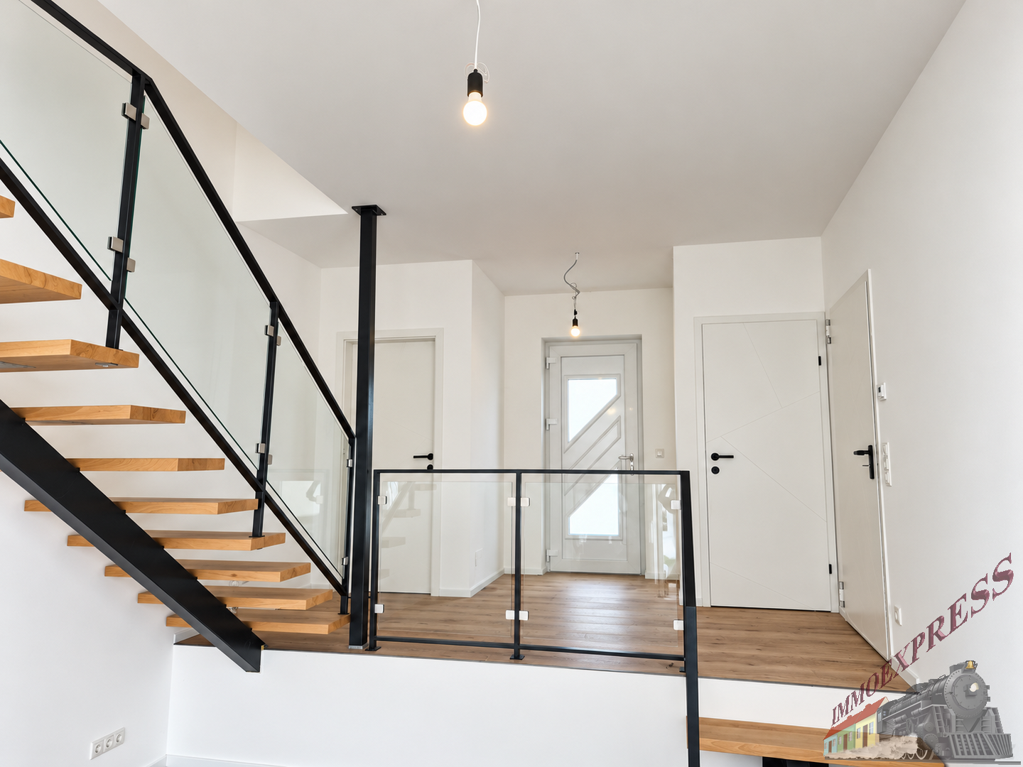 Moderne Eingangsbereich mit Holztreppe und Glasgeländer